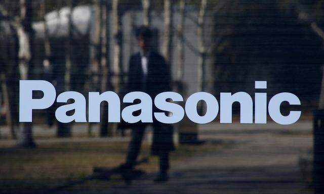 FILE PHOTO: A man is reflected on Panasonic Corp's logo at Panasonic Center in Tokyo