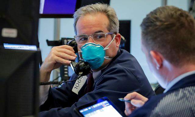 FILE PHOTO: A trader wears a face mask on the floor  of the NYSE in New York