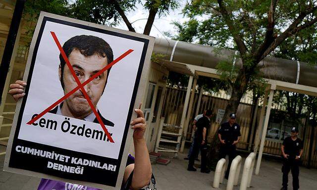 A woman holds a portrait of Cem Ozdemir, a member of German Bundestag and co-chairman of Greens Party, during a protest in front of the German Embassy in Ankara