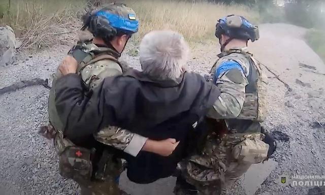 Eine Person in Charkiw wird von Einsatzkräften in Sicherheit gebracht. Man halte russische Einheiten „so gut wir können“ derzeit zurück, so Selenskij.