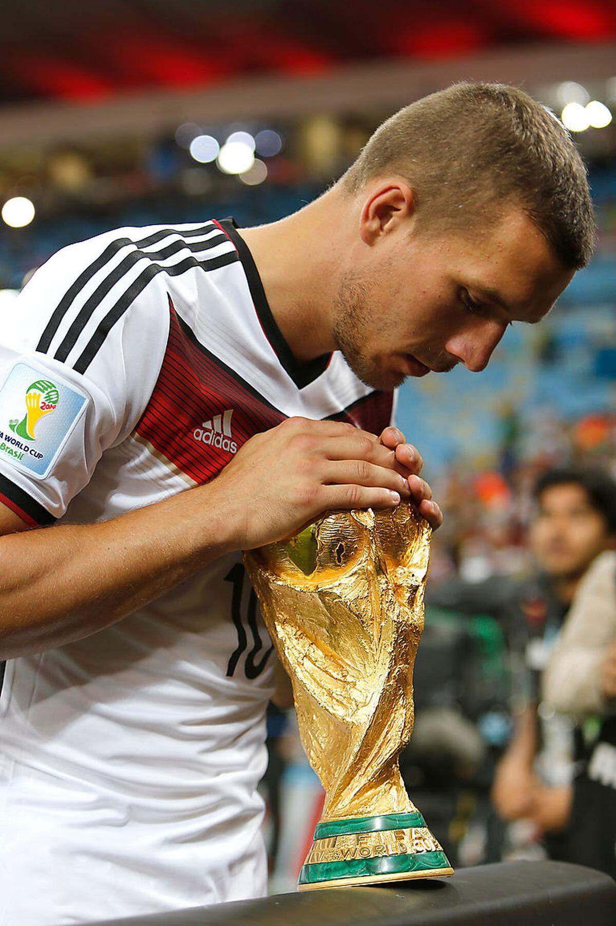 Das Original (hier in Händen von Lukas Podolski) bleibt für gewöhnlich im Hauptquartier des Fußball-Weltverbandes in der Schweiz. Der amtierende Weltmeister erhält eine vergoldete Nachbildung aus Bronze.