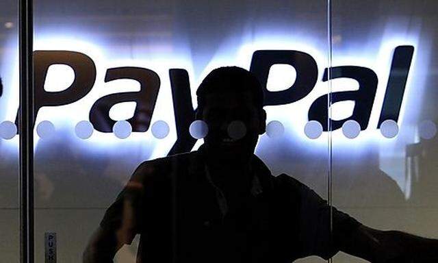 FILE - In this March 17, 2010 file photo, a PayPal employee walks past the PayPal logo at the interna