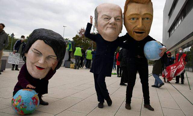 Demonstranten mit Masken der Ampel-Koalitionsverhandler  Annalena Baerbock (Grüne), Olaf Scholz (SPD) und Christian Lidnner (FDP) am 15.10. 2021 in Berlin. 
