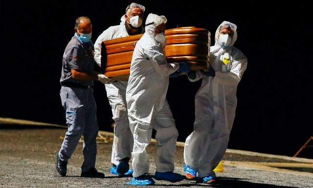 Rescuers from the Spanish Coast Guard carry a coffin containing the recovered body of one of the four deceased migrants to a transfer van at the port of La Restinga, on the Canary Island of El Hierro
