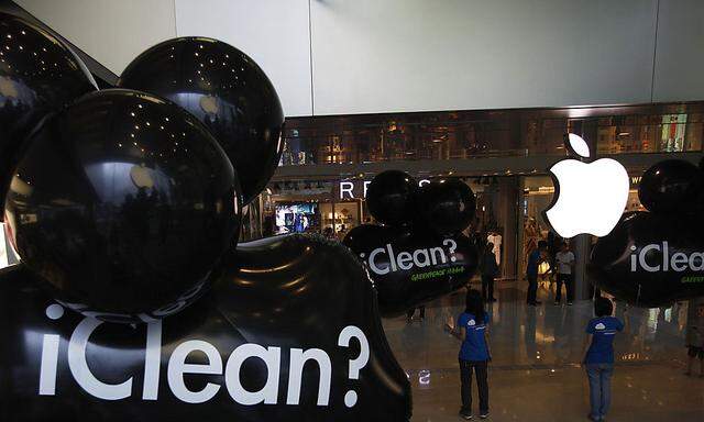 Greenpeace activists carry balloons with the word ´iClean´ during a protest inside an Apple store in Hong Kong