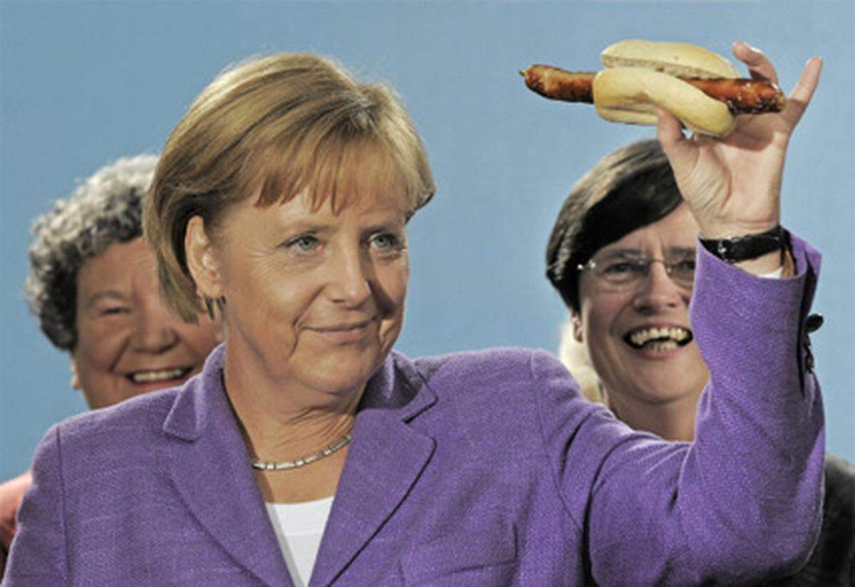 Wer die Stimmen der Wähler will, muss auch essen, was den Wählern schmeckt. So dachte es sich die Kanzlerin und posierte mit einer Original Thüringer Grillwurst für die Kameras.