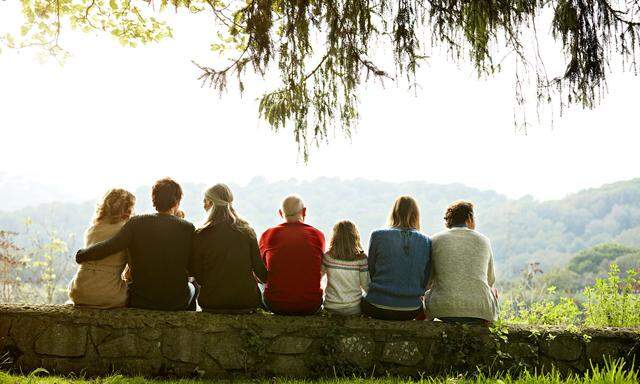 Multi-generation family relaxing on retaining wall