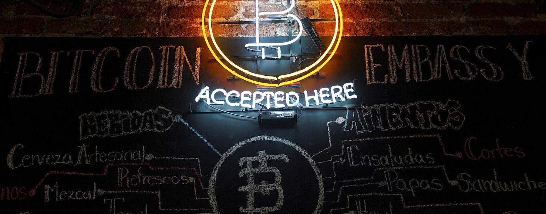 A neon logo of virtual cryptocurrency Bitcoin is seen at the Bitcoin Embassy bar in this illustration