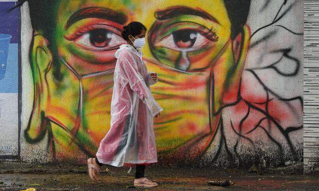 Straßenszene mit Wandgemälde in der indischen Metropole Mumbai in Zeiten der Covid-19-Pandemie.