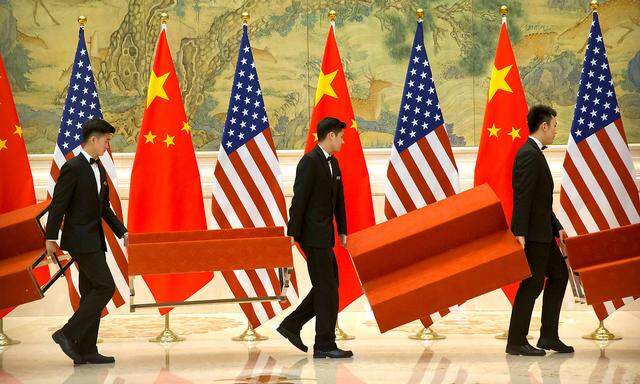 Aides set up platforms before a group photo with members of U.S. and Chinese trade negotiation delegations at the Diaoyutai State Guesthouse in Beijing