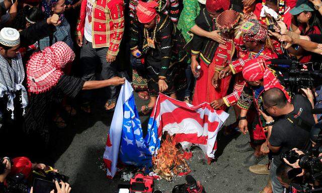 Various activists' and Indigenous People's group burn a mock U.S. flag as they hold a rally supporting President Rodrigo Duterte's independent foreign policy in metro Manila