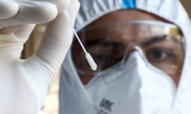 A health worker holds a swab stick, in Vienna