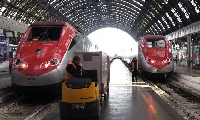 A workers sits on his vehicle next to Frecciarossa high speed trains at the Central railway station in Milan
