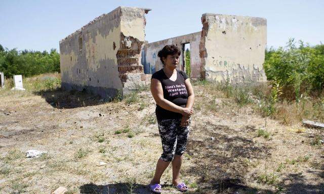 Erzsebet Csorba steht vor den Ruinen des Hauses in Tatarszentgyorgy in denen ihr Sohn Robert und ihr Enkel umbegracht wurden. 