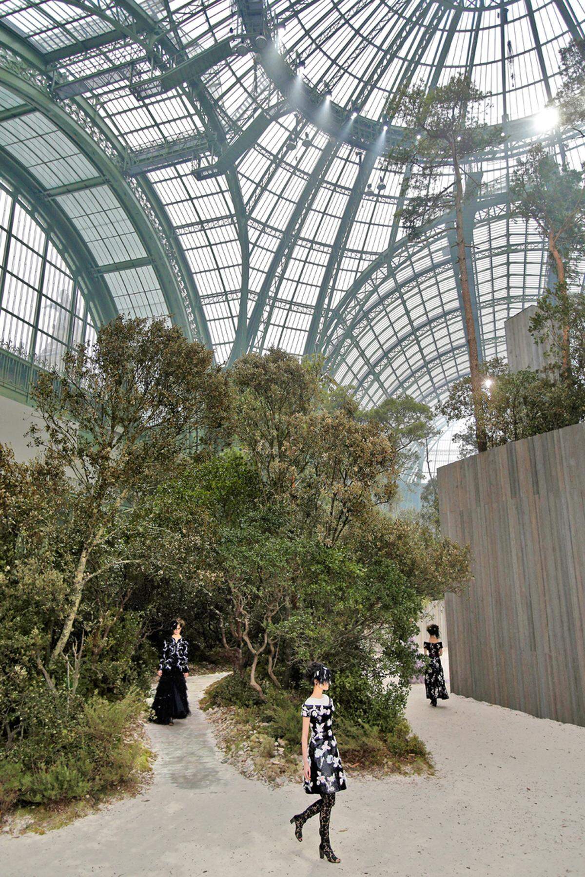 Das Maison Chanel lässt es sich nicht nehmen, Saison um Saison den wunderbaren, für die Pariser Weltausstellung im Jahr 1900 errichteten Glaspalast des „Grand Palais“ zu bespielen. Diesmal sah Karl Lagerfeld den Wald vor lauter Bäumen nicht und ließ üppige Gewächse in dieses Show-Setting verpflanzen.