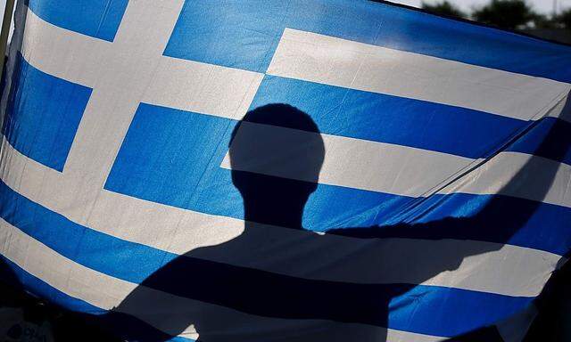 A nationalist holds a Greek flag during a protest against government plans to build the first official mosque in an Athens neighborhood