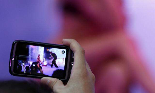 A visitor takes a picture of a porno show during the Erotica Dream exhibition in Nice