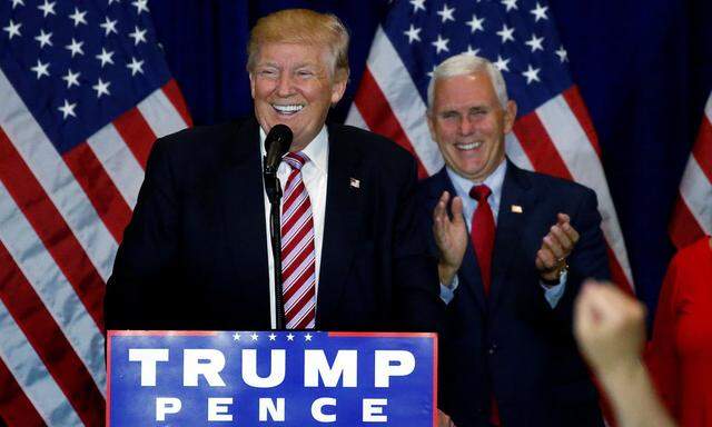 Republican presidential candidate Donald Trump (L) speaks as vice presidential candidiate Mike Pence claps at a post Republican Convention campaign event in Cleveland