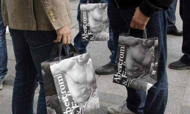 Shoppers hold bags with purchases on the opening day of operations by retailers Abercrombie & Fitch outside their Paris store