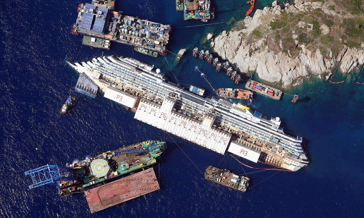 26. August 2013. Eine Luftaufnahme vom havarierten Kreuzfahrtschiff Costa Concordia fast zwei Jahre nach dem Unglück. Im September 2013 konnte das vor der italienischen Insel Giglio liegende Schiffswrack aufgerichtet und bald darauf abgeschleppt werden.