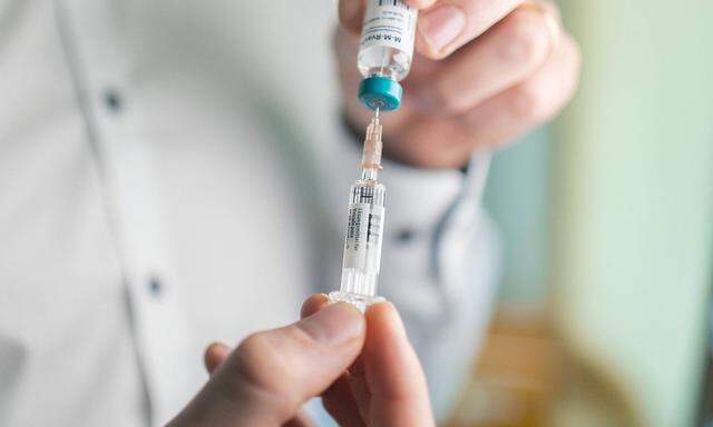 Arzt mit einer Spritze mit Impfstoff fuer eine Masern Impfung, Bonn, 27.03.2019. Gestellte Aufnahme. Bonn Deutschland *