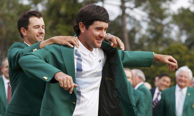 Watson, has 2013 winner Scott, present him his green jacket after winning the Masters golf tournament at the Augusta National Golf Club in Augusta