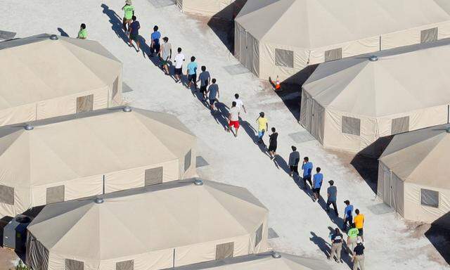 FILE PHOTO: Immigrant children now housed in a tent encampment under the new 'zero tolerance' policy by the Trump administration are shown walking in single file at the facility near the Mexican border in Tornillo, Texas