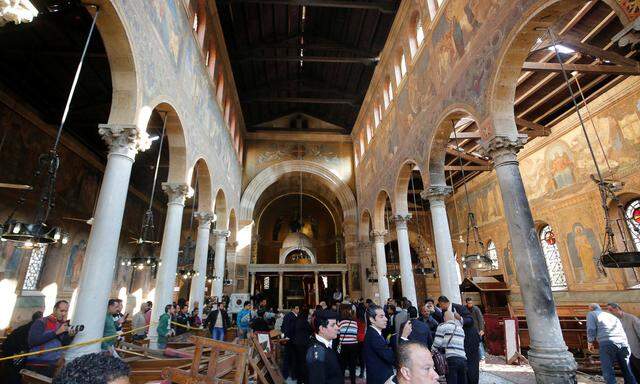Egyptian security officials and investigators inspect the scene following a bombing inside Cairo's Coptic cathedral in Egypt
