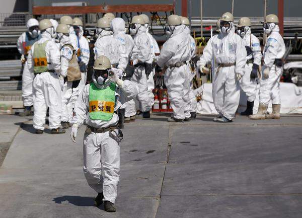Nach Angaben des Fukushima-Betreibers Tepco wird es noch bis zu 40 Jahre dauern, bis das Kraftwerk vollständig gesichert ist. Bild: Arbeiter in Schutzanzügen beim Reaktor 4 des AKW Fukushima.
