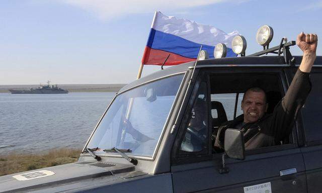 A member of a pro-Russian self defence unit gestures as he drives past the Ukrainian naval landing vessel ´Konstantin Olshansky´ in Donuzlav bay in Crimea