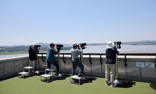 Menschen blicken von einer Aussichtsplattform in Paju nahe der entmilitarisierten Zone, die die beiden Koreas trennt, am 4. Juni 2024 durch ein Fernglas in Richtung Nordkorea.