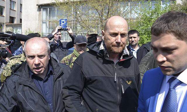 OSCE observer Schneider is escorted after being freed by pro-Russian separatists in the town of Slaviansk