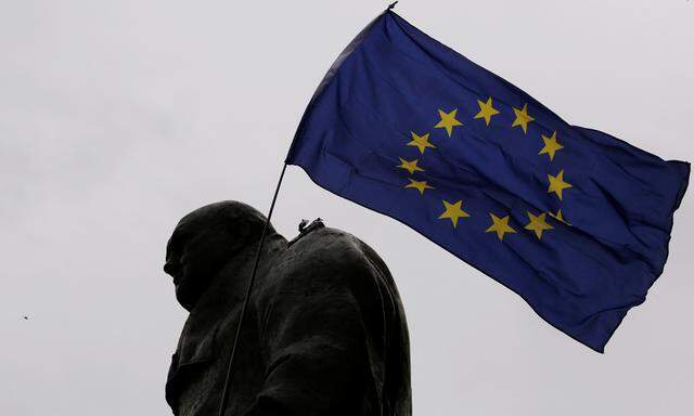 A European Union flag is waved over a statue of former Prime Minister Winston Churchill as demonstrators protest during a ´March for Europe´ against the Brexit vote result earlier in the year, in London, Britain