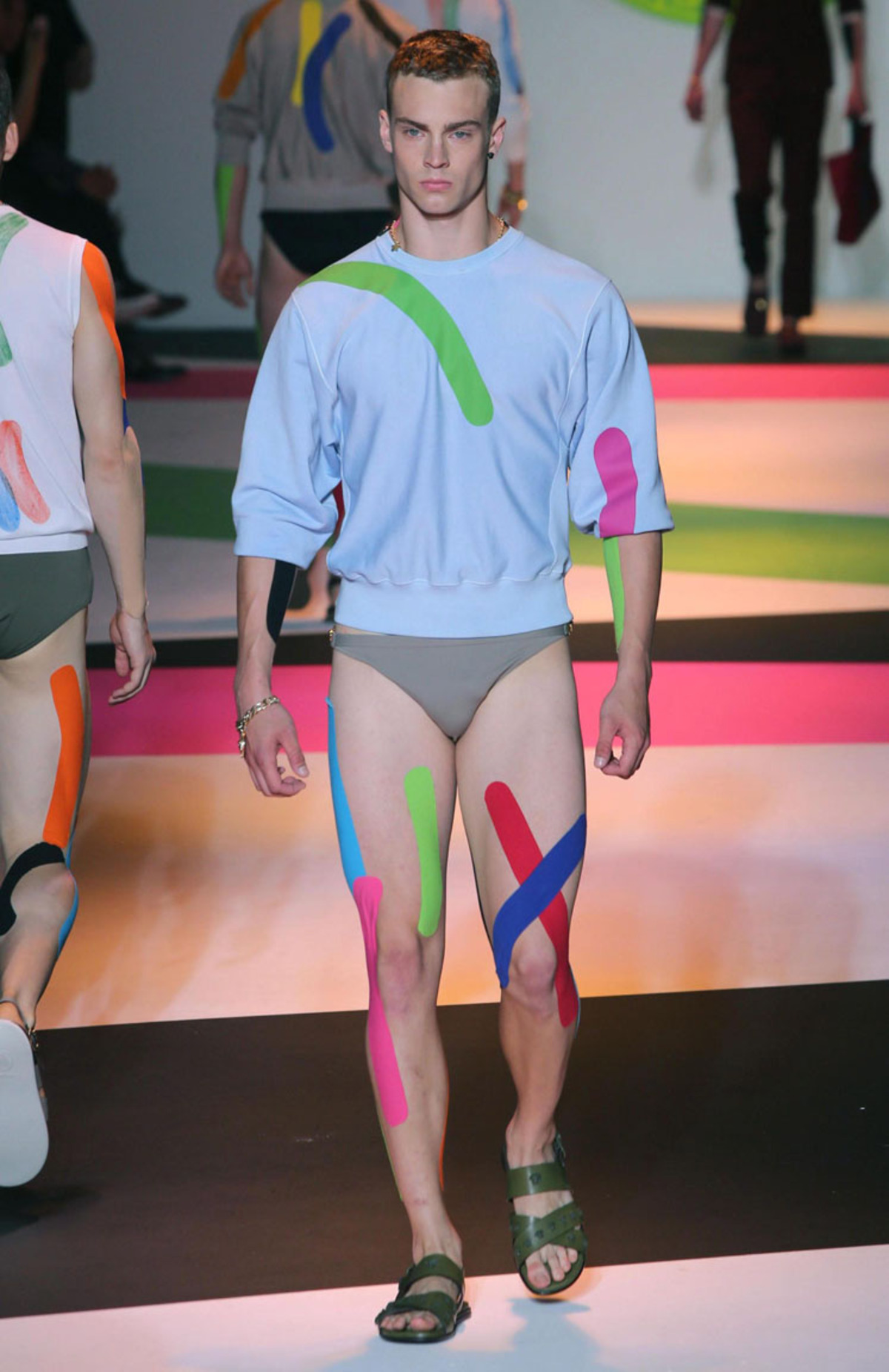 Dieser Look von Versace  lässt sich mitunter selbst nachmachen. Kinesio-Tapes, die Sportler bei Verletzungen tragen, setzten bunte Akzente.
