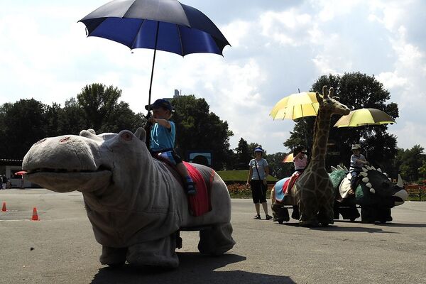 Auf elektromotorisierten Stofftieren reiten die Kinder beim Donaupark-Eingang Arbeiterstrandbadgasse.