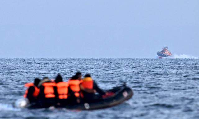 Boot der britischen Küstenwache (Hintergrund) nähert sich einem aus Frankreich kommenden Schlauchboot mit Zuwanderungswilligen. (Archivbild, undatiert).