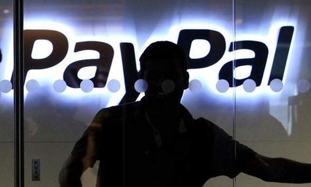 FILE - In this March 17, 2010 file photo, a PayPal employee walks past the PayPal logo at the interna