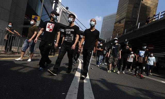 Anti-Occupy Central protesters wearing masks approach barricades, set up by pro-democracy protesters, before being stopped by the police in Hong Kong