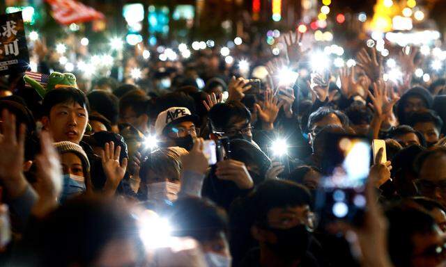 Im Schein der Mobiltelefone: In Hongkong gingen am Sonntag Zehntausende Menschen auf die Straße. 