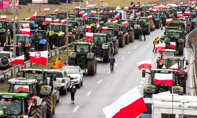 Polnische Bauern blockieren mit ihren Traktoren eine Straße. 