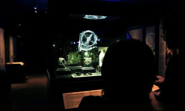 Visitors look at the displayed fragments of the ancient Antikythera Mechanism at the National Archaeological Museum in Athens