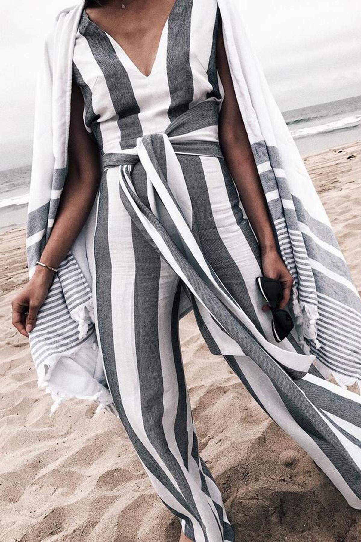 Ein zum Outfit passendes Strandtuch als Poncho getragen sieht nicht nur lässig aus, sondern erspart auch unnötiges Schleppen. 