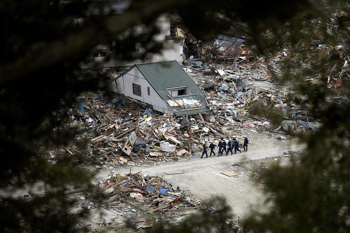 In Ishinomaki geht ein Suchtrupp durch ein völlig zerstörtes Wohngebiet. (4. April)