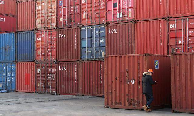 FILE PHOTO: Worker checks containers at a logistics center near Tianjin port, in Tianjin, China