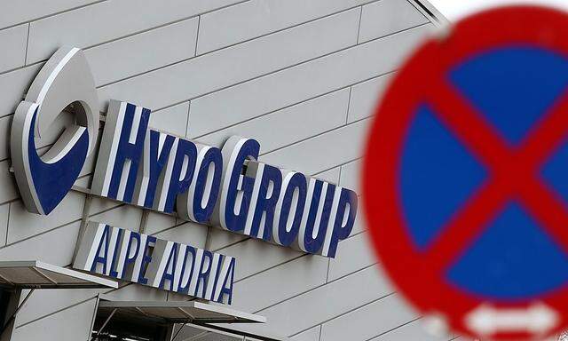 The logo of Hypo Alpe Adria is pictured behind a traffic sign at the bank's headquarters in Klagenfurt