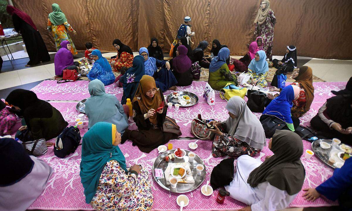 Die letzten zehn Nächte des Ramadan gelten als besonders heilig. Der Fastenmonat endet am 27. Tag mit dem Freudenfest Eid al-Fitr. Das Fest des Fastenbrechens ist einer der wichtigsten muslimischen Feiertage: Das zweitägige Fest beginnt in Österreich am 14. Juni und endet am Abend des 15. Juni. Eine Gruppe von muslimischen Frauen wartet auf das Fastenbrechen vor der Darul Makmur-Moschee in Singapur