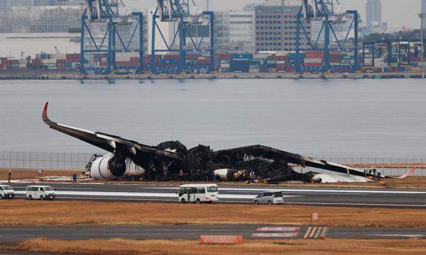 Officials investigate a burnt Japan Airlines (JAL) Airbus A350 plane after a collision with a Japan Coast Guard aircraft at Haneda International Airport in Tokyo, Japan January 3, 2024.  REUTERS/Issei Kato