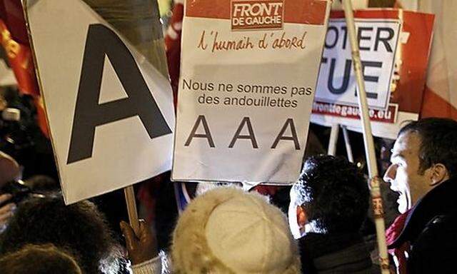 Demonstrators from the left-wing Parti de Gauche political party demonstrate outside the offices of S