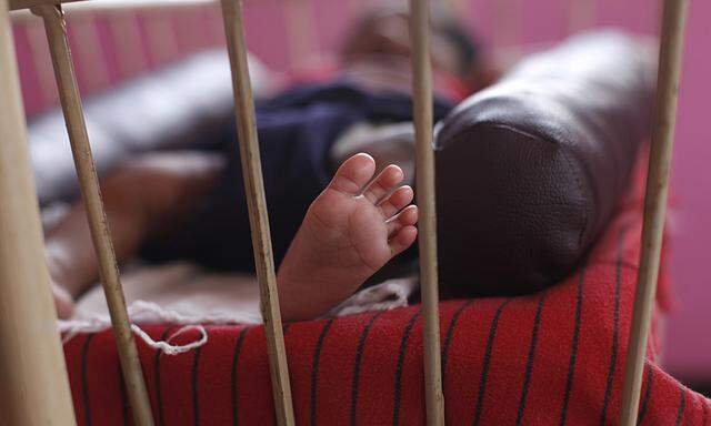 A baby girl is seen lying in a cradle inside the Life Line Trust orphanage in Salem