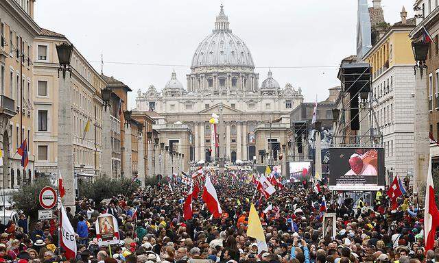 Catholic faithful gather along Via Della Conciliazione in front of St. Peter´s Square to attend the canonisation ceremony of Popes John XXIII and John Paul II at the Vatican